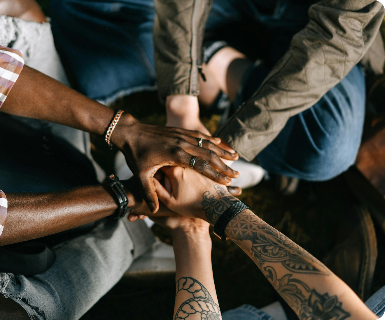 Diverse hands joined in unity circle.