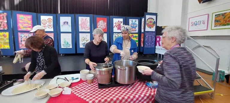 Community event with people preparing noodles.