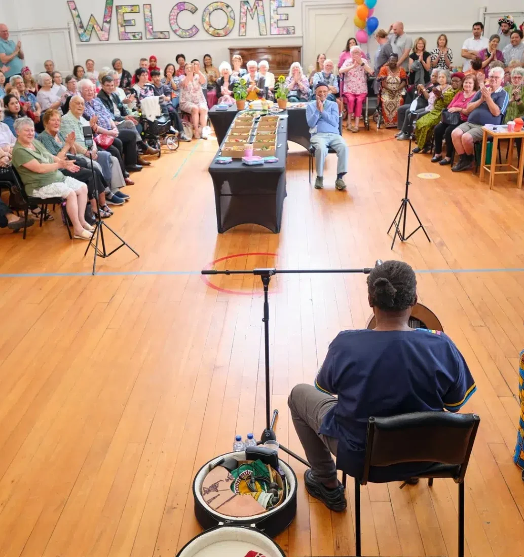 Community gathering with drum performance in hall.