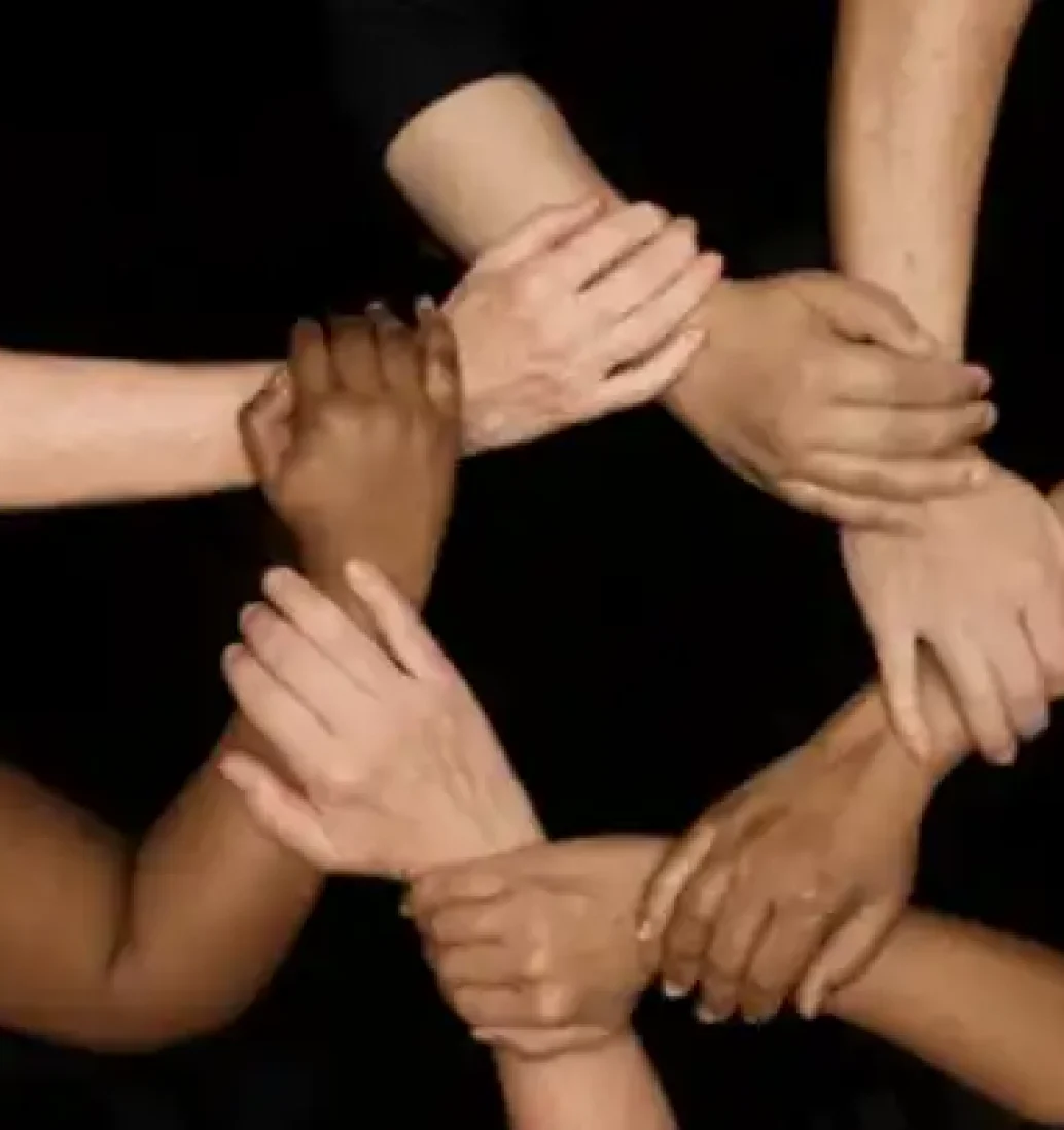 Diverse hands forming a unity circle.